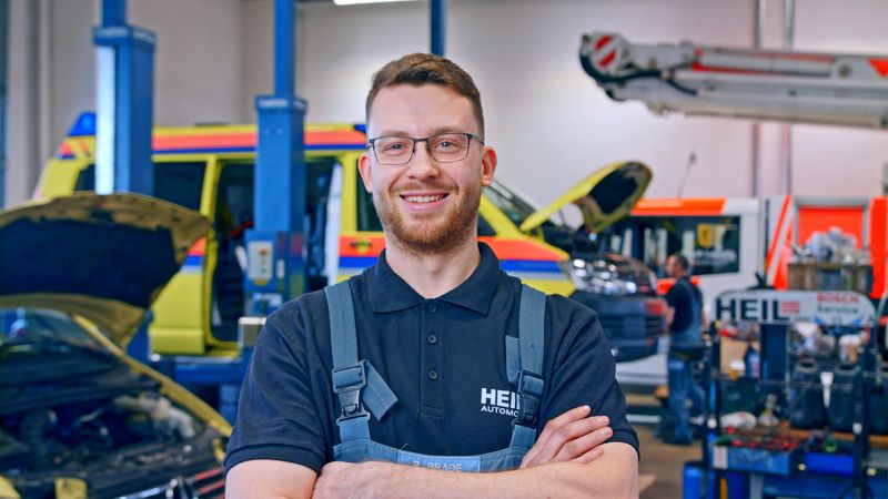 Mitarbeiter von Heil Automobile lächelt in der Werkstatt